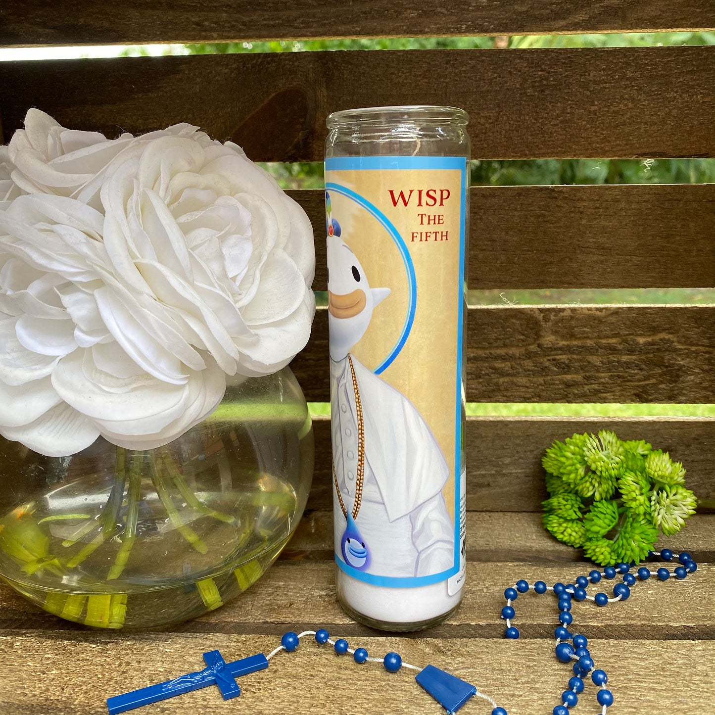 a vase of flowers and a rosary on a bench