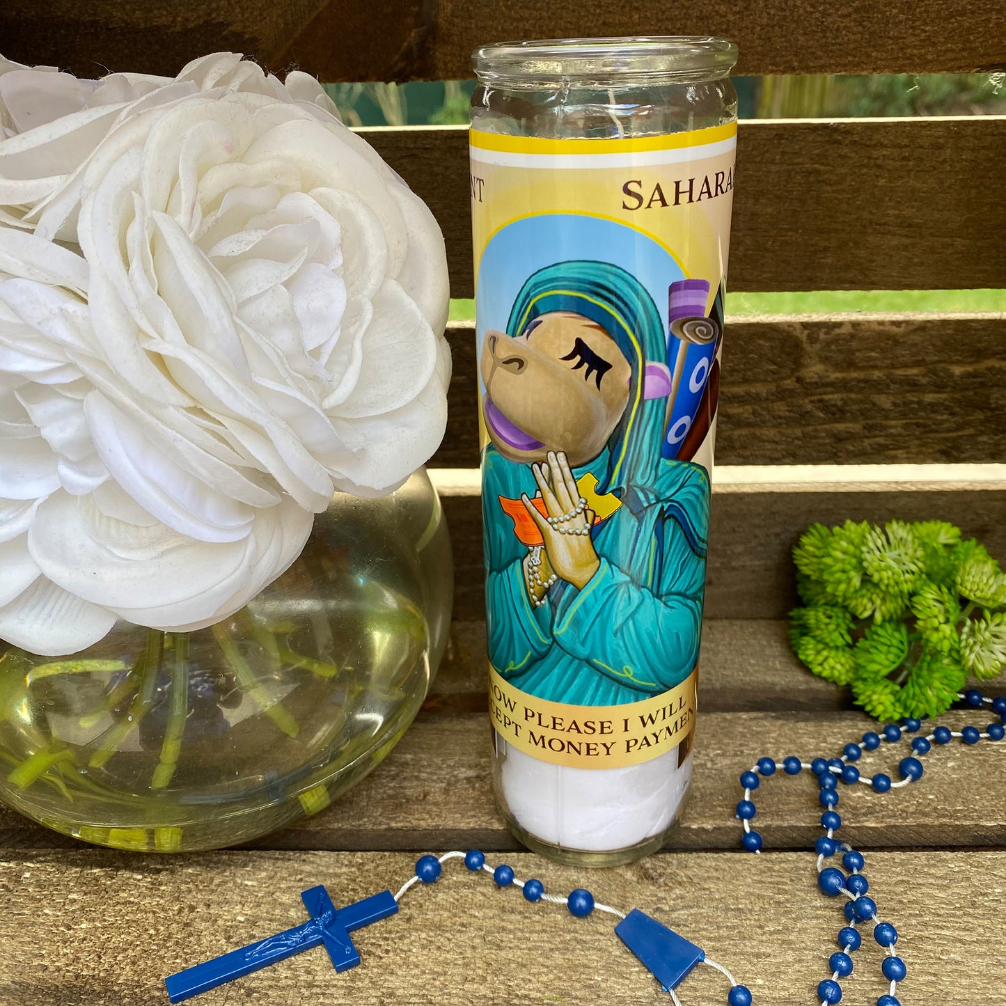 a candle and rosary on a wooden table