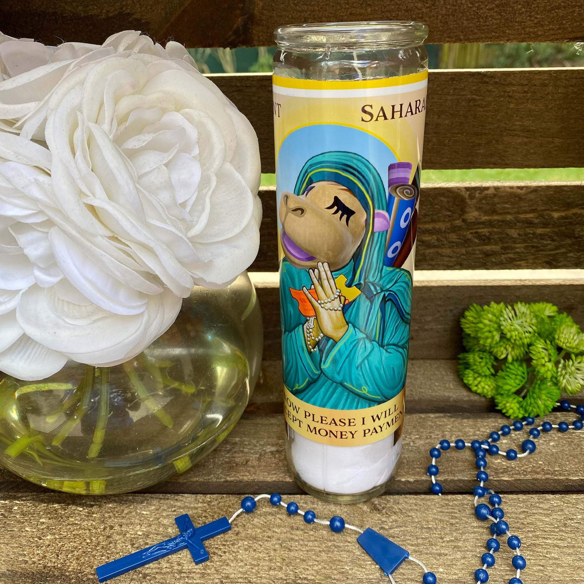 a candle and rosary on a wooden table