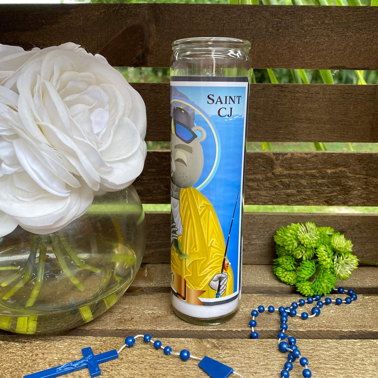 a vase with flowers and a rosary on a bench