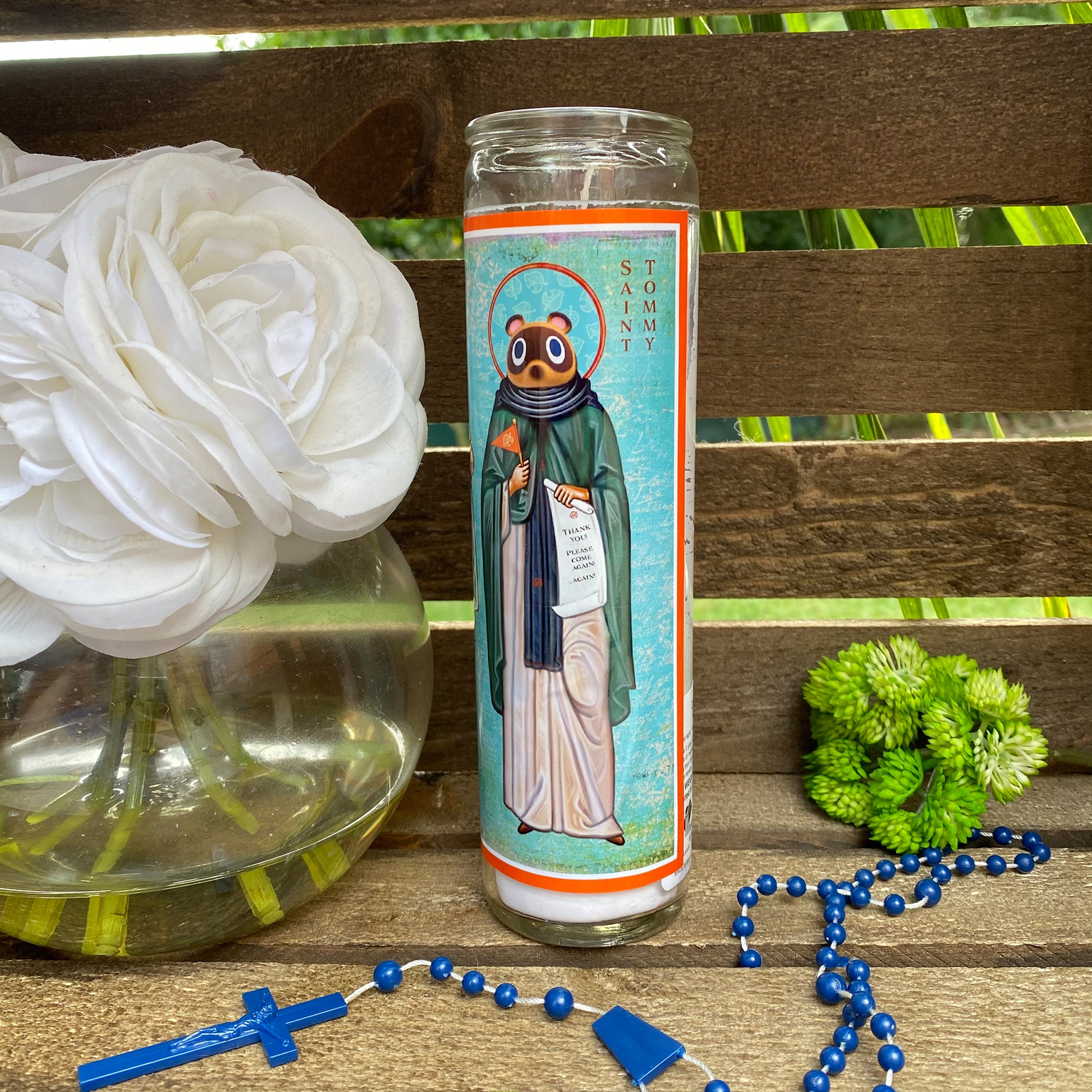 a vase with flowers and a rosary on a table