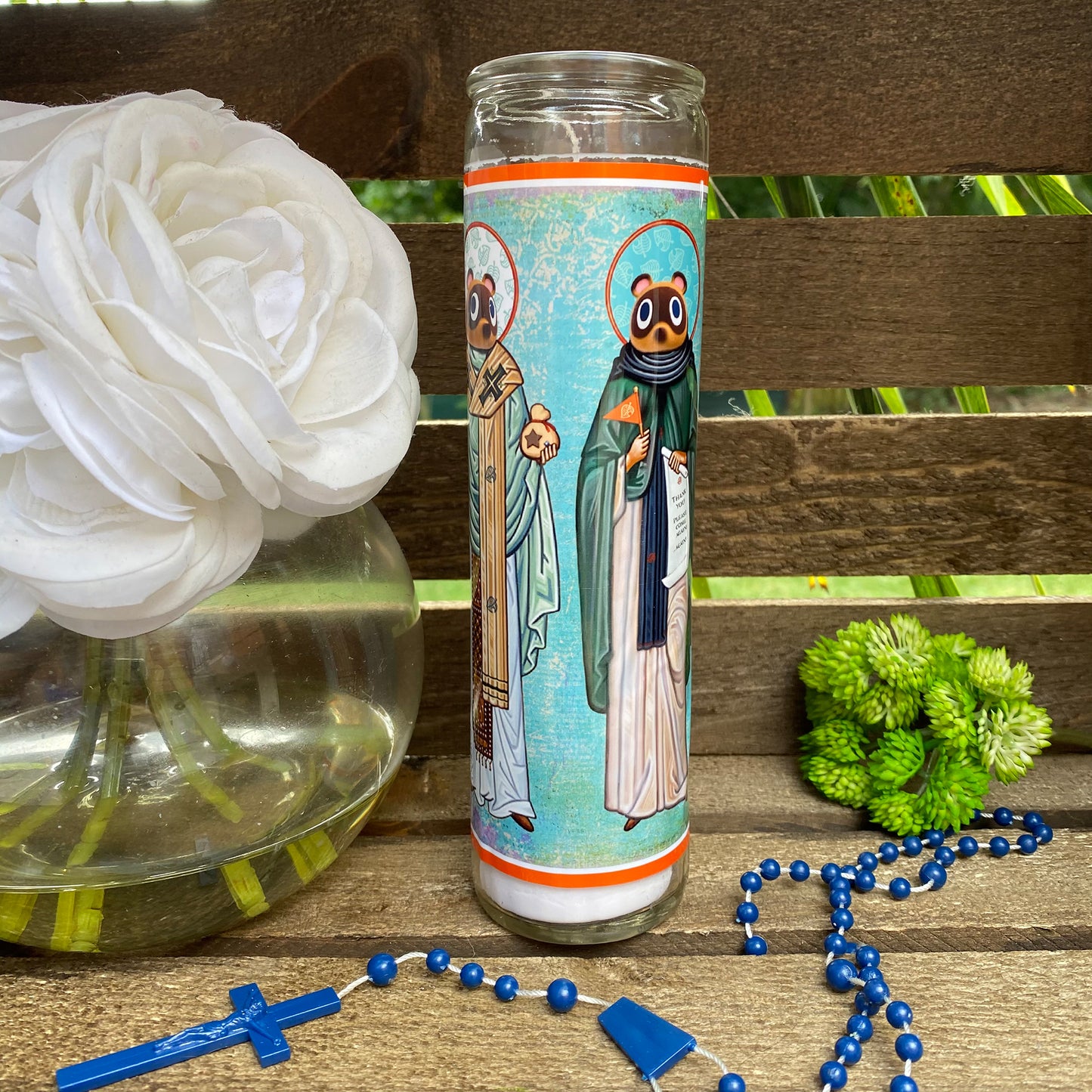 a glass with a picture of two people on it next to a rosary and a