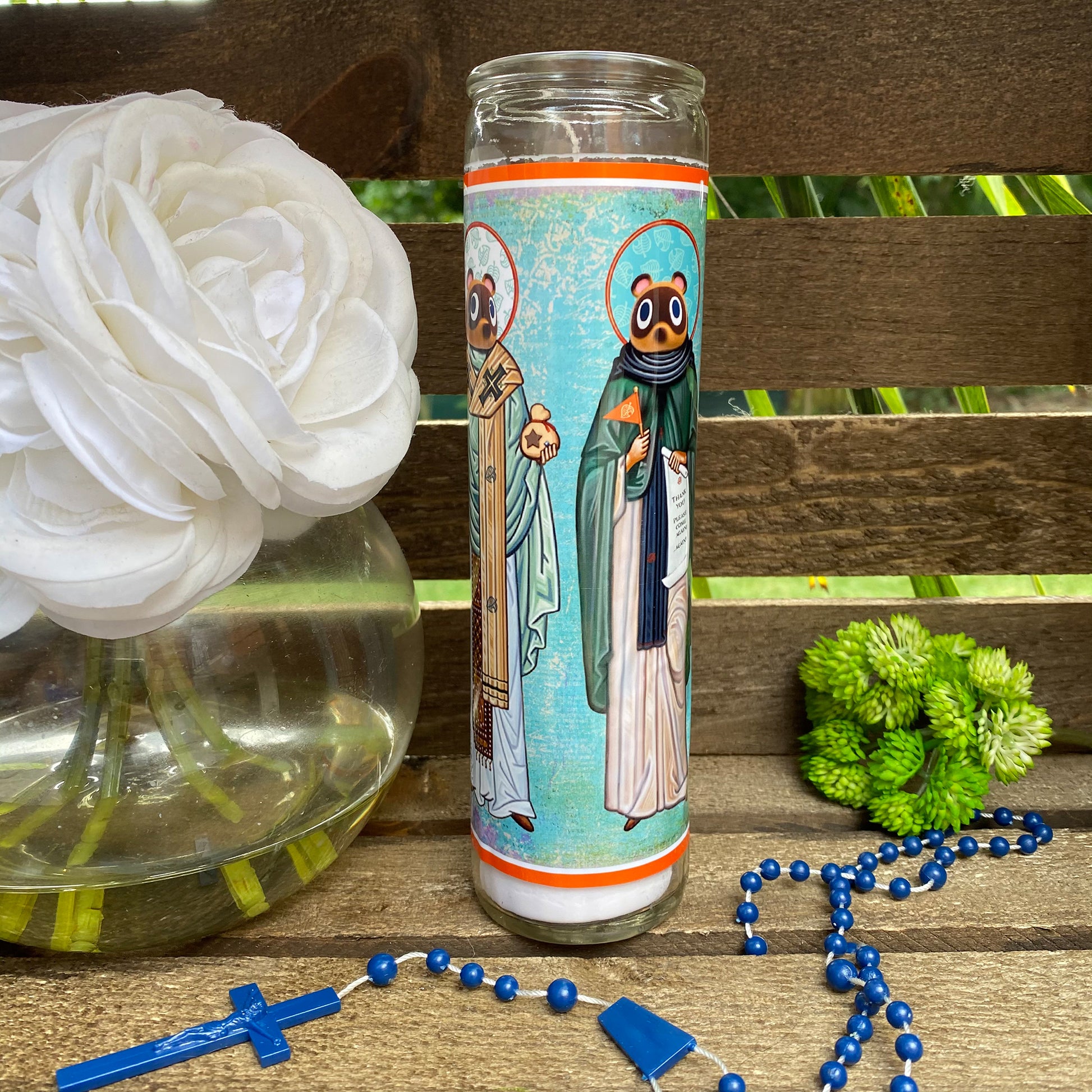 a glass with a picture of two people on it next to a rosary and a
