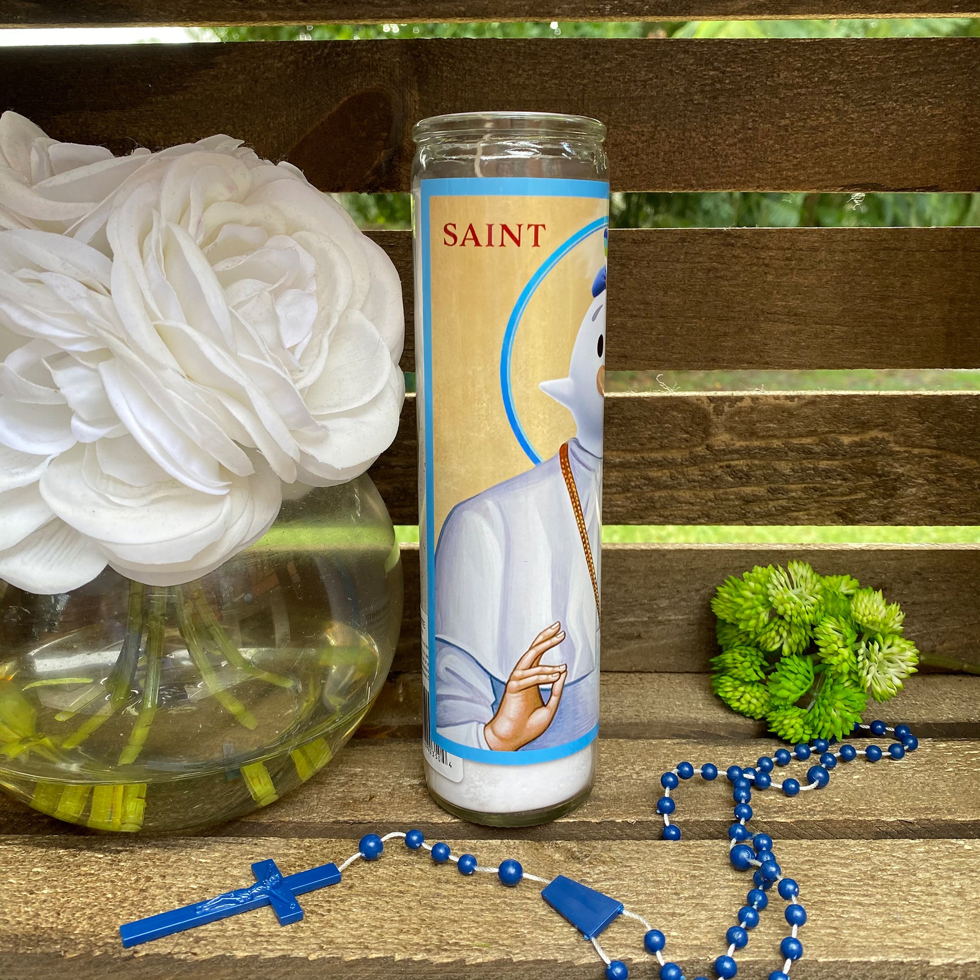 a rosary, a vase of flowers, and a bottle of water on a bench