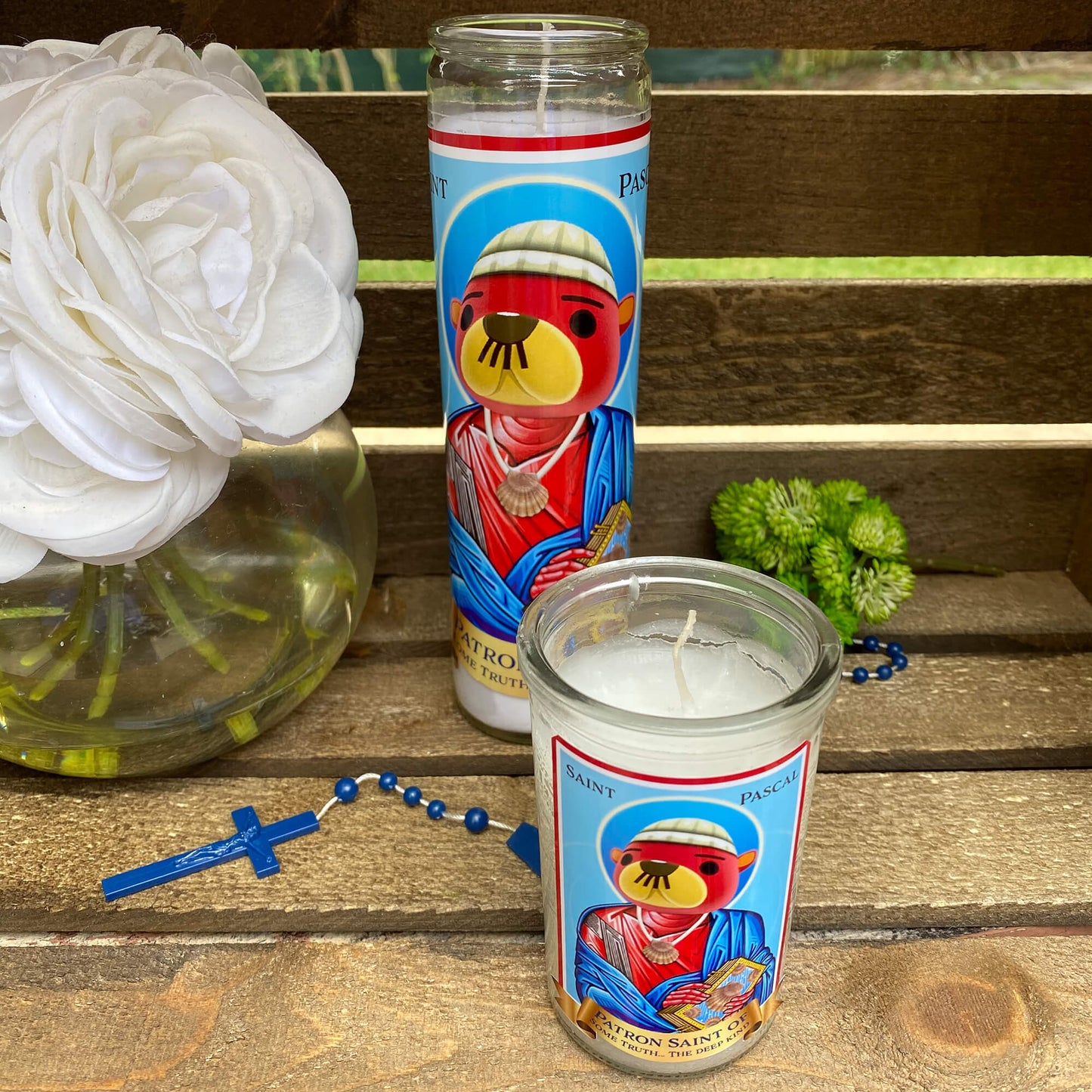 a candle and some flowers on a bench