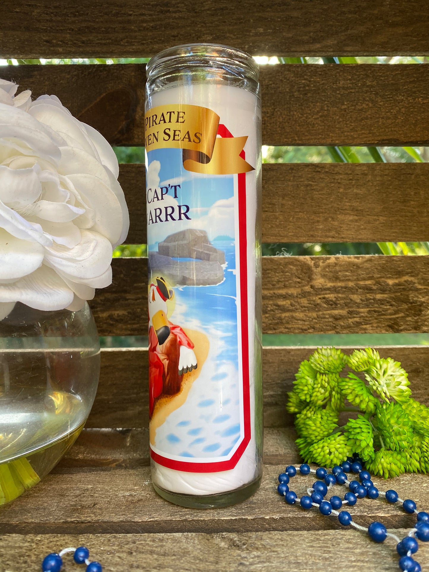 a candle with a picture of a boat on it next to a flower