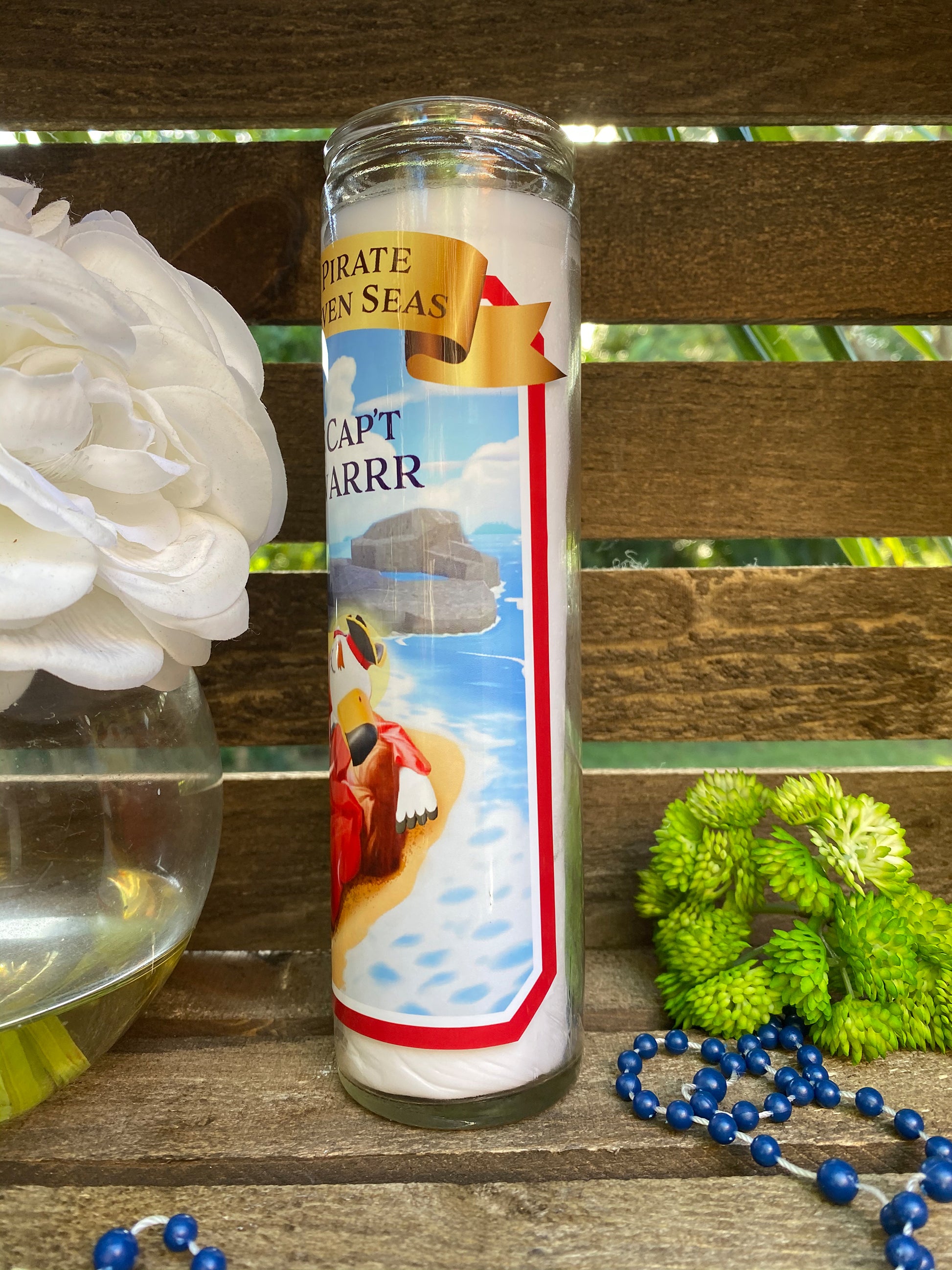 a candle with a picture of a boat on it next to a flower