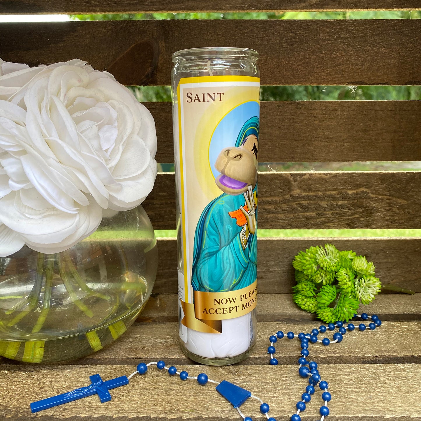 a candle and rosary on a wooden bench