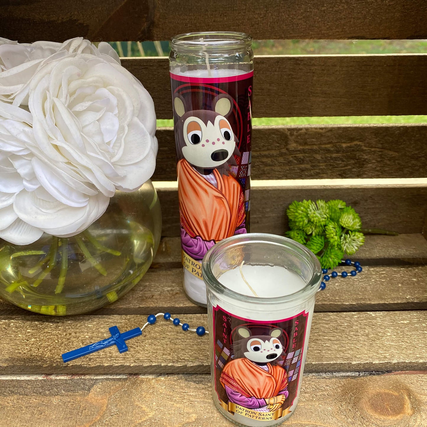 a candle and some flowers on a bench
