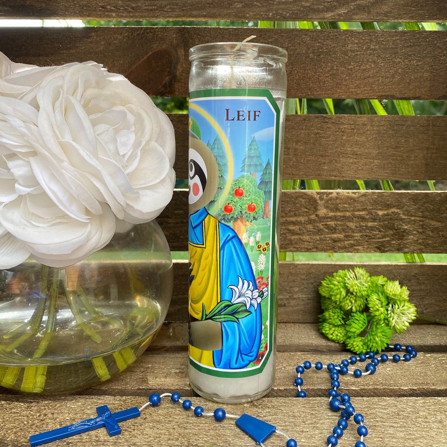 a white flower sitting next to a candle on a wooden table