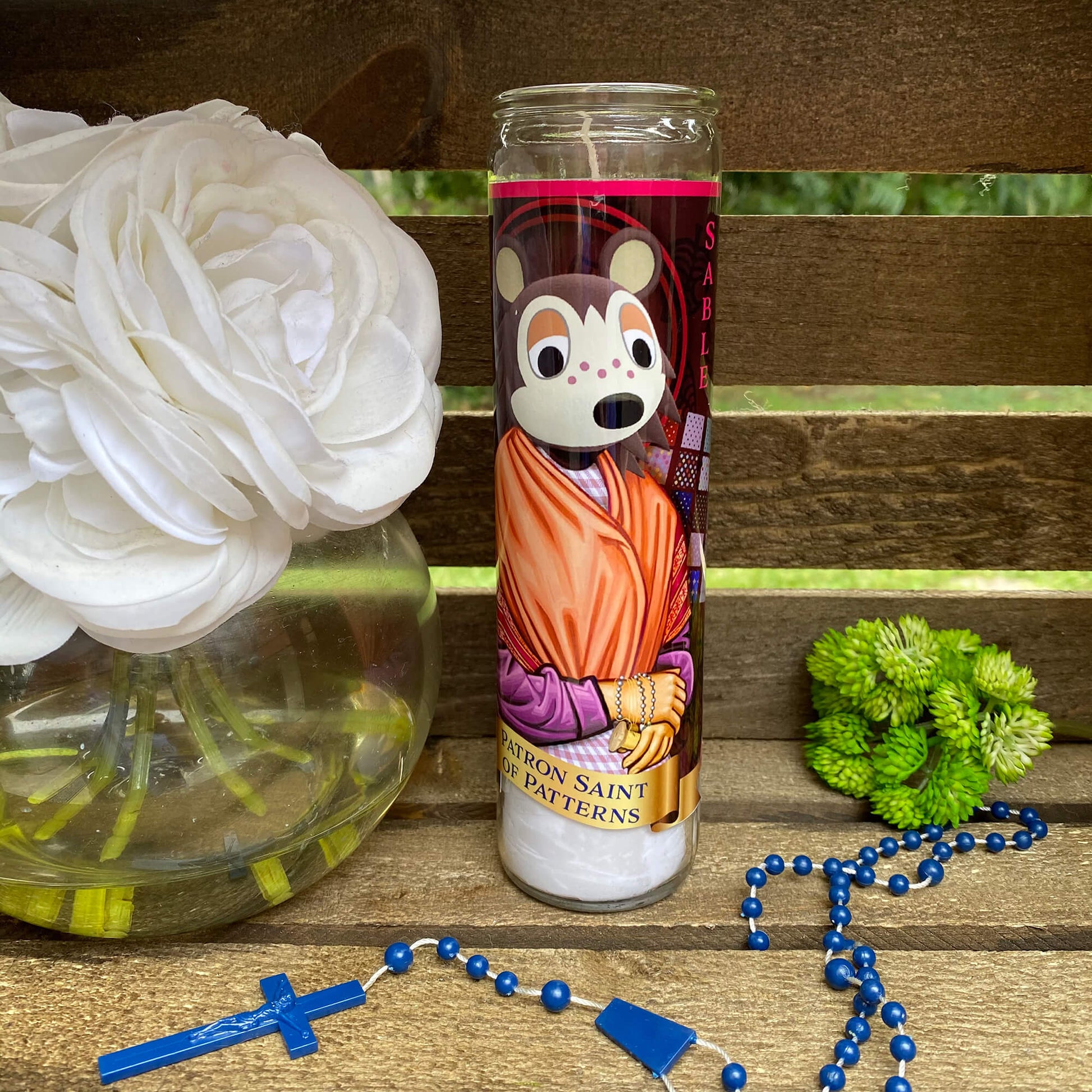 a vase with flowers and a rosary on a table