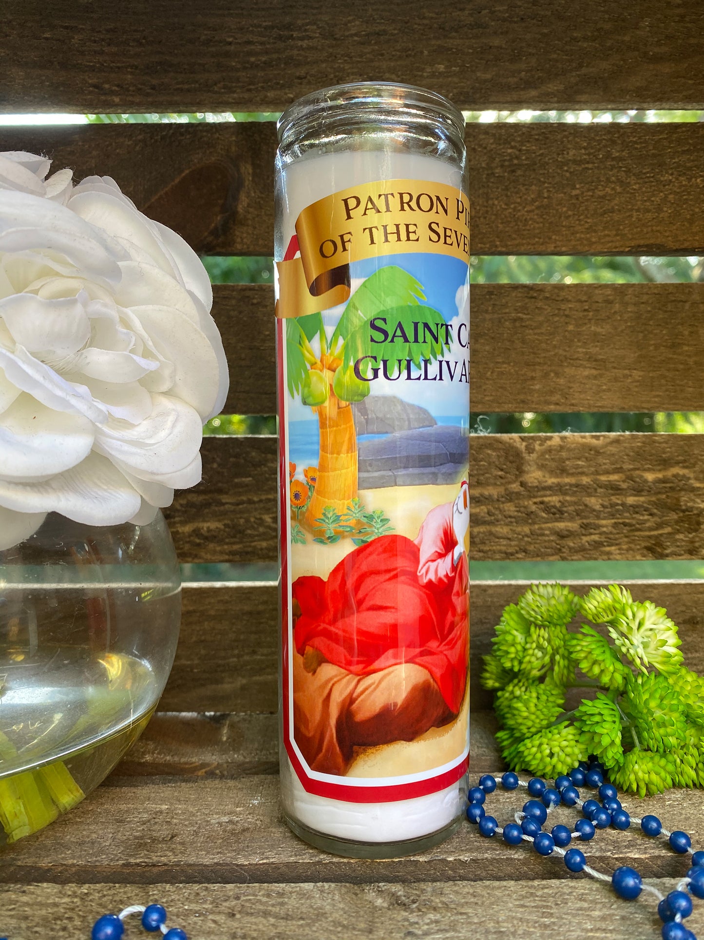 a candle sitting on a table next to a flower