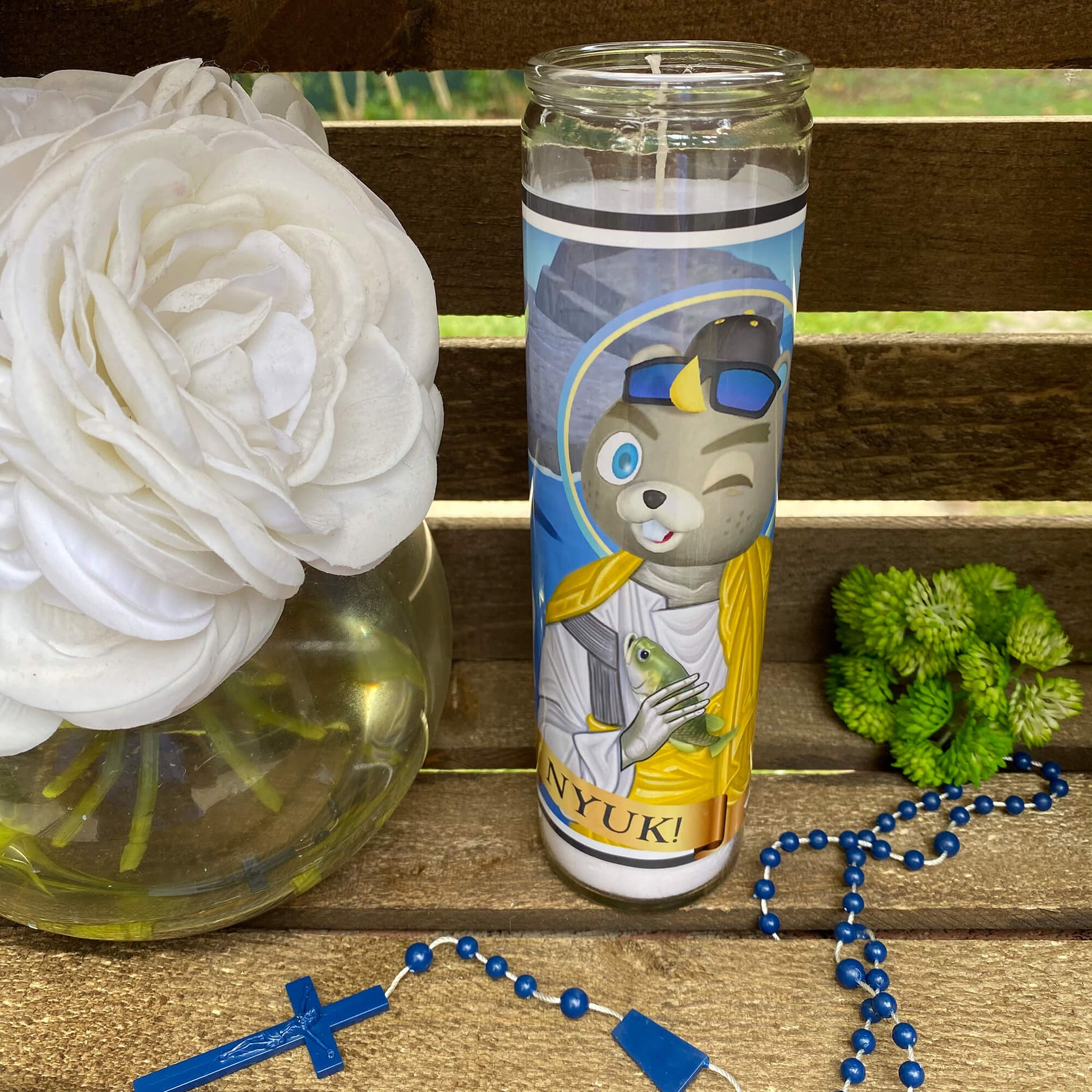 a vase with a flower and a rosary on a bench