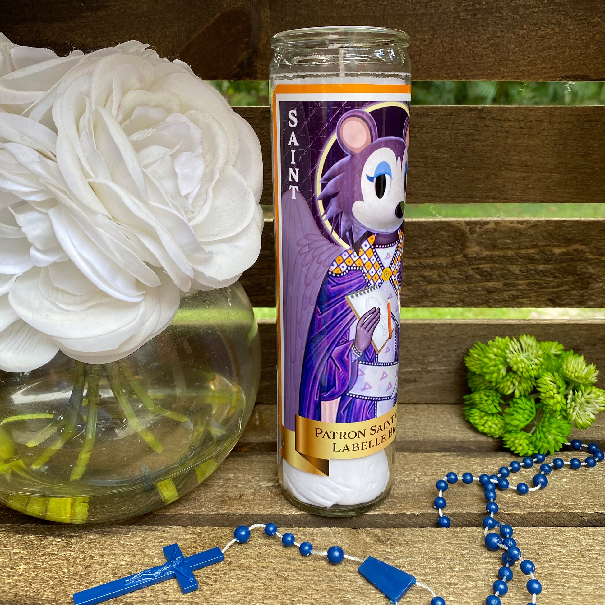 a candle and rosary on a wooden table