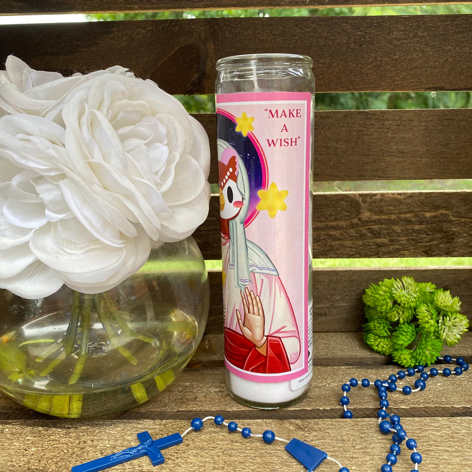 a vase of flowers and a candle on a bench