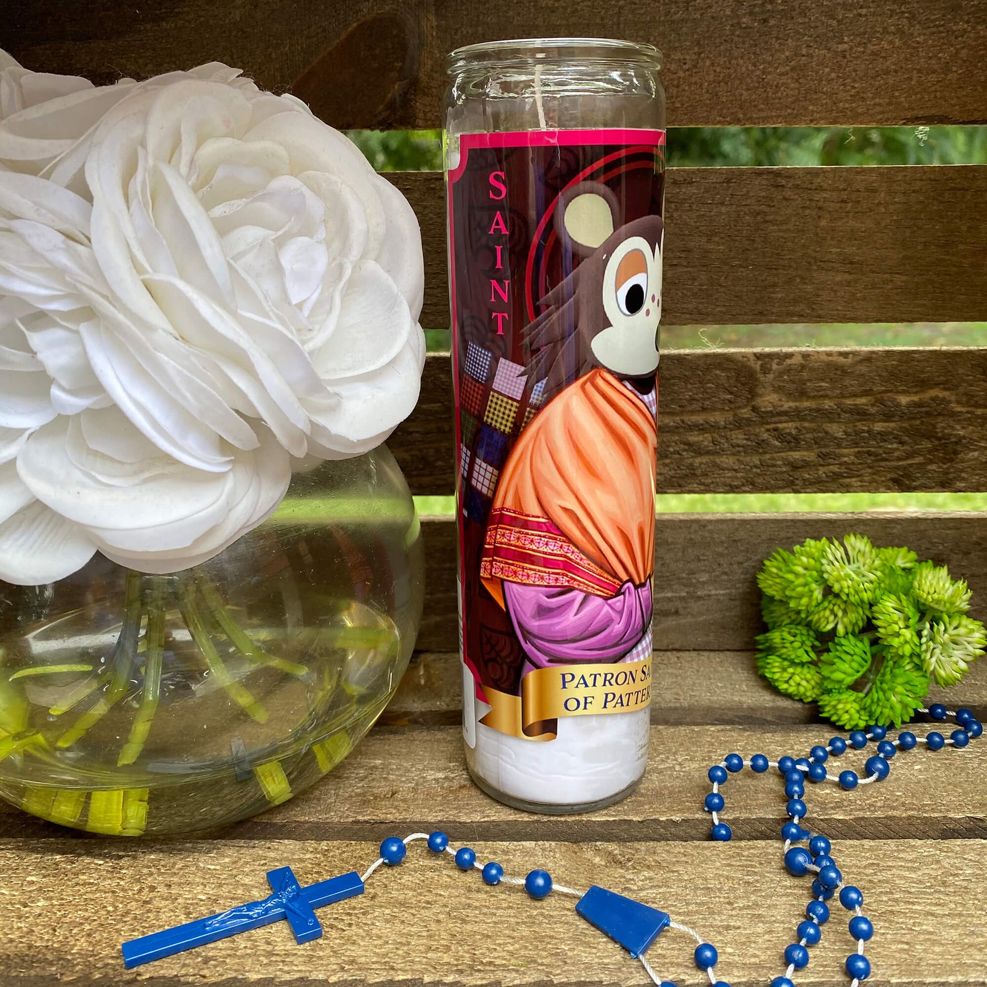 a cup with a bear on it next to a rosary and flowers