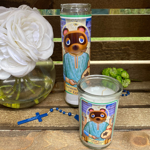 a candle with a bear on it next to a vase with flowers