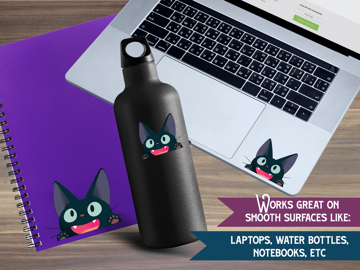 a black cat water bottle next to a laptop