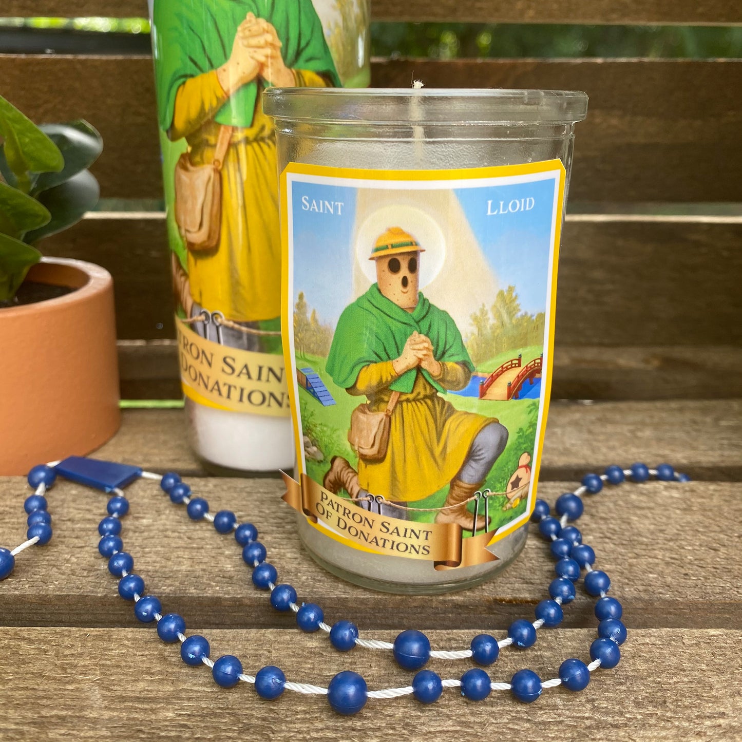 a candle with a blue bead necklace next to it