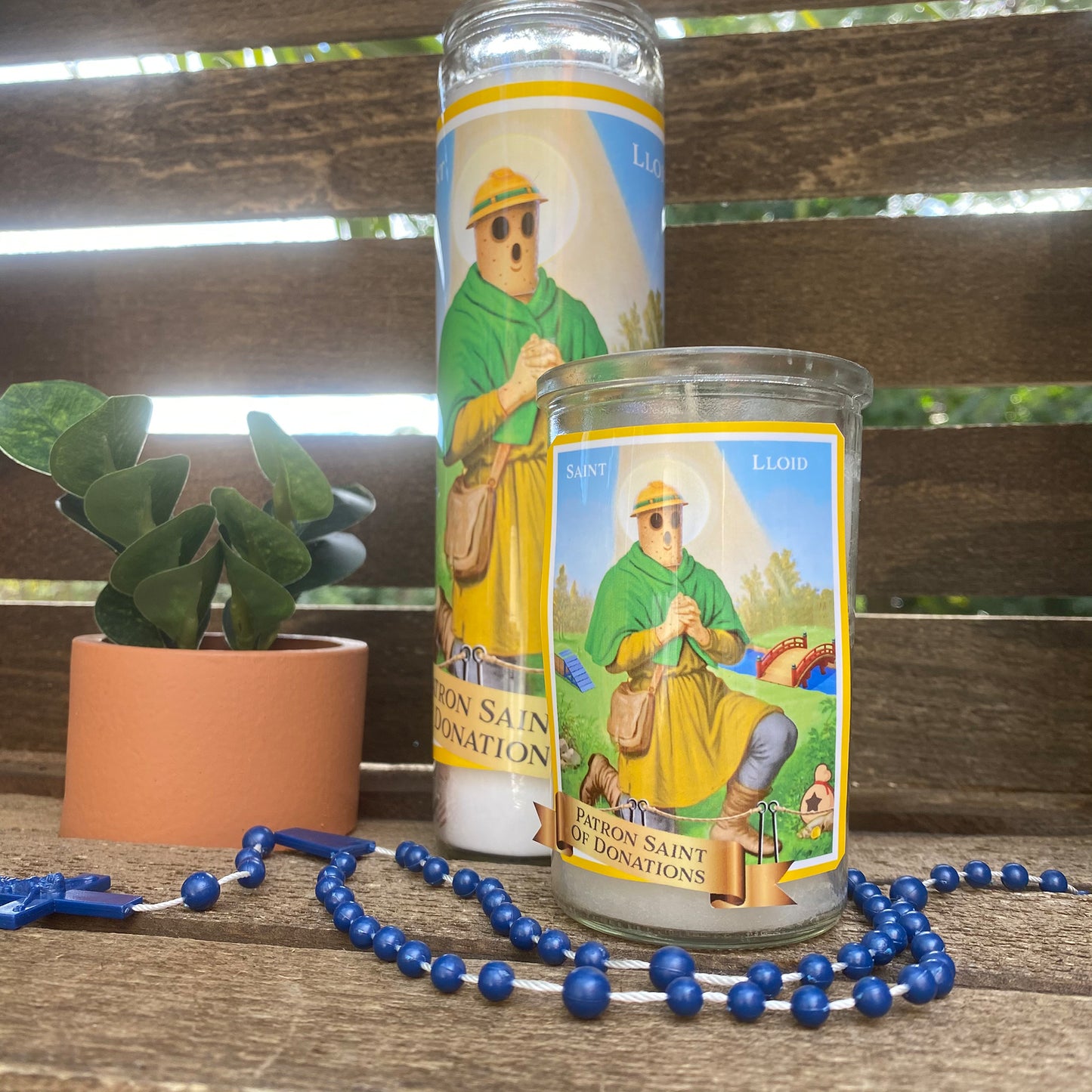 a candle and rosary on a wooden bench