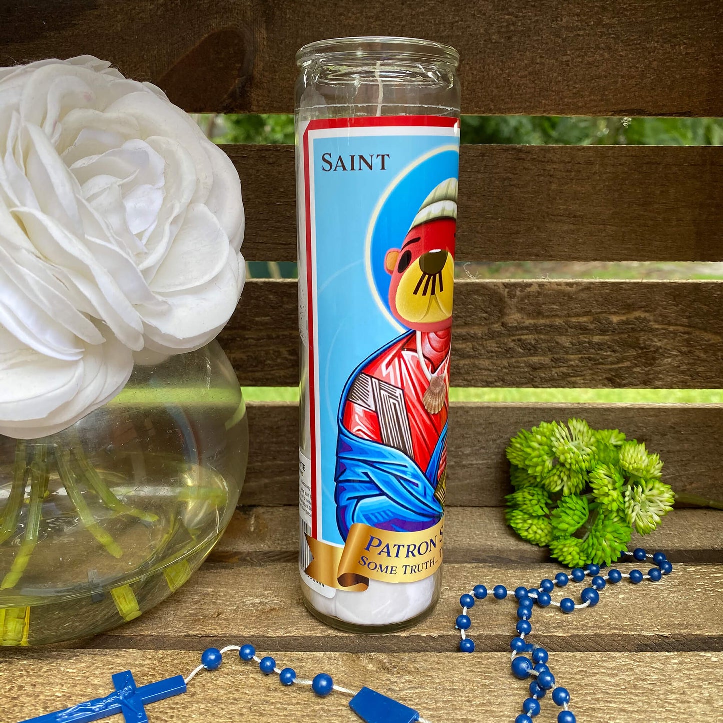 a rosary and a bottle of saint anthony on a bench