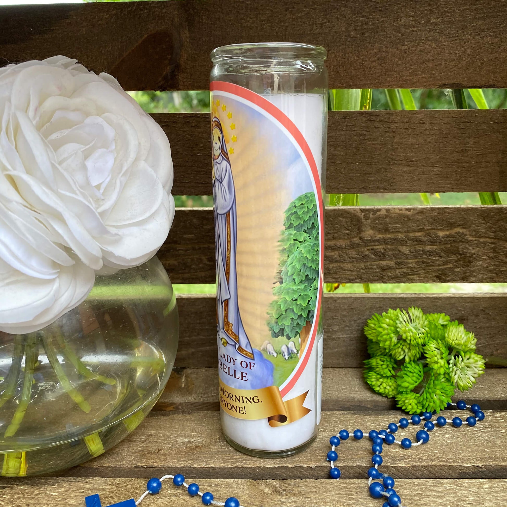 a vase with a flower and a rosary on a bench