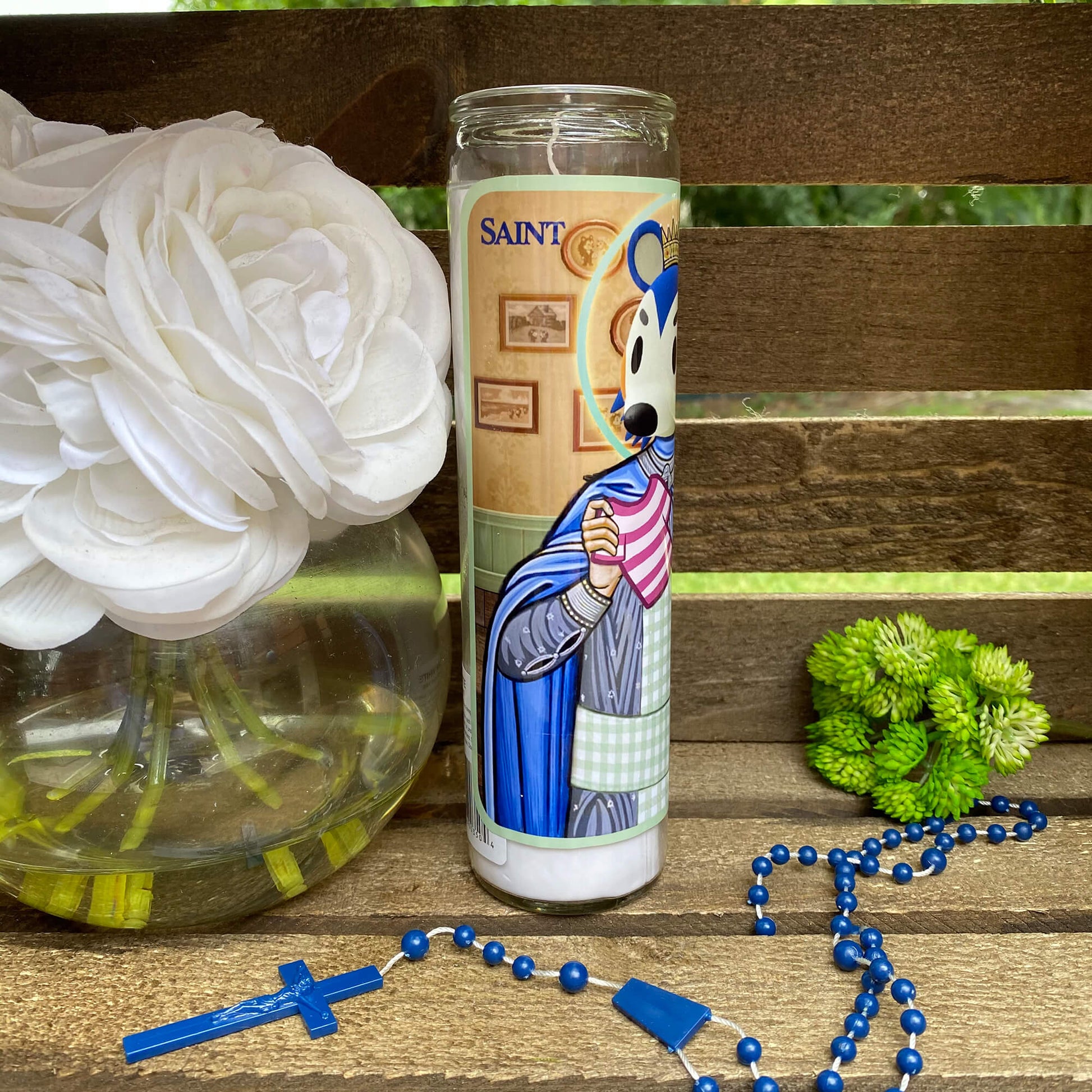 a candle and rosary on a wooden bench