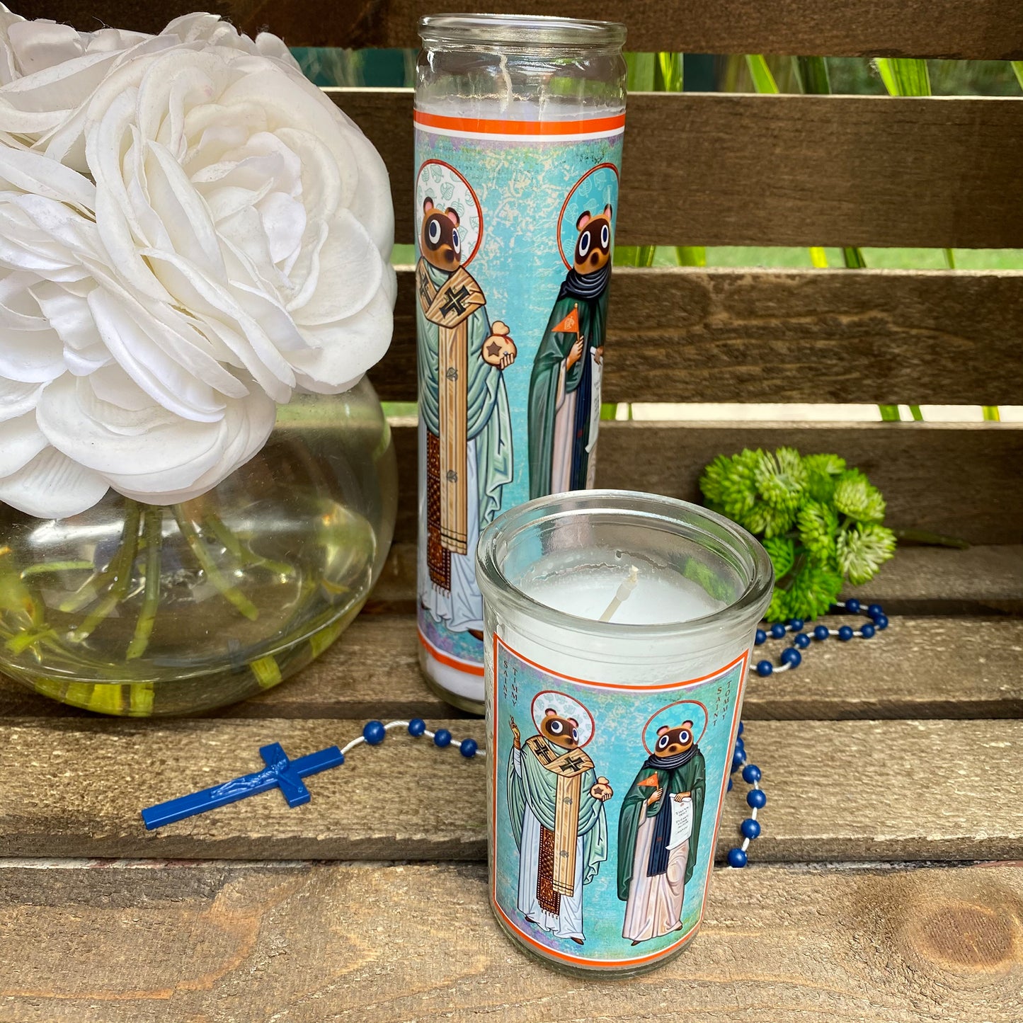 a candle and some flowers on a bench