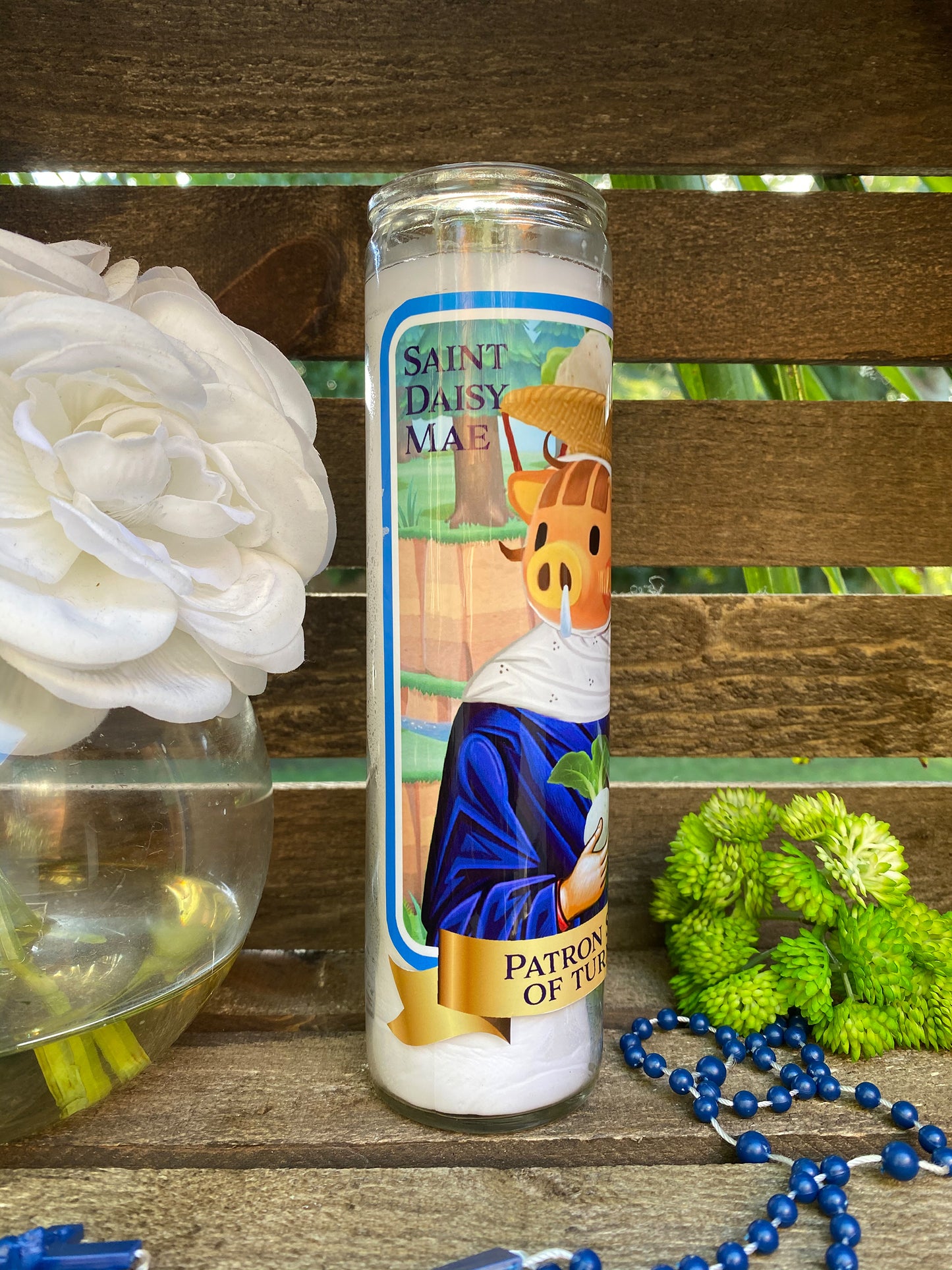 a white flower sitting next to a candle on top of a wooden table