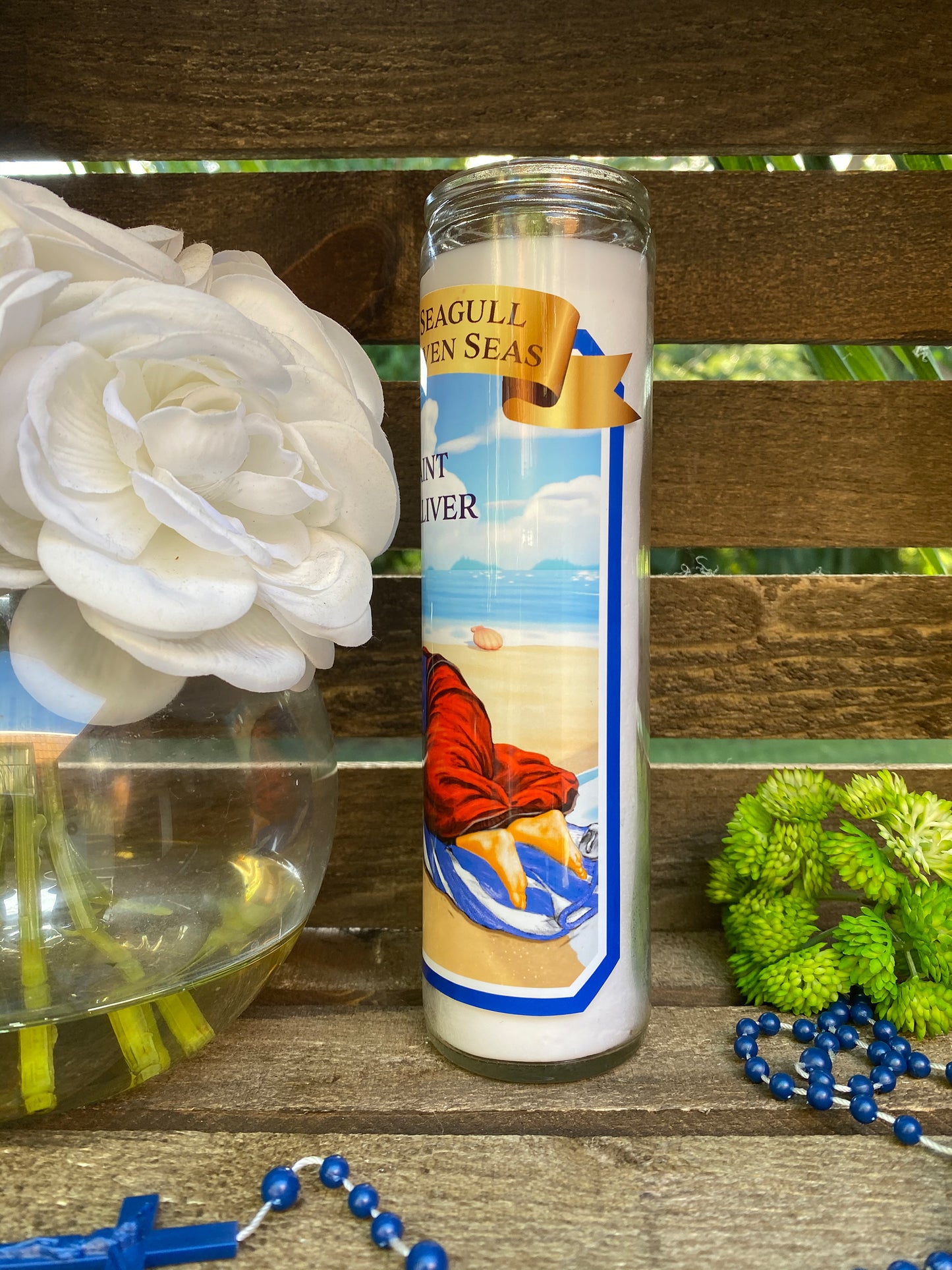 a white flower sitting next to a candle on a table