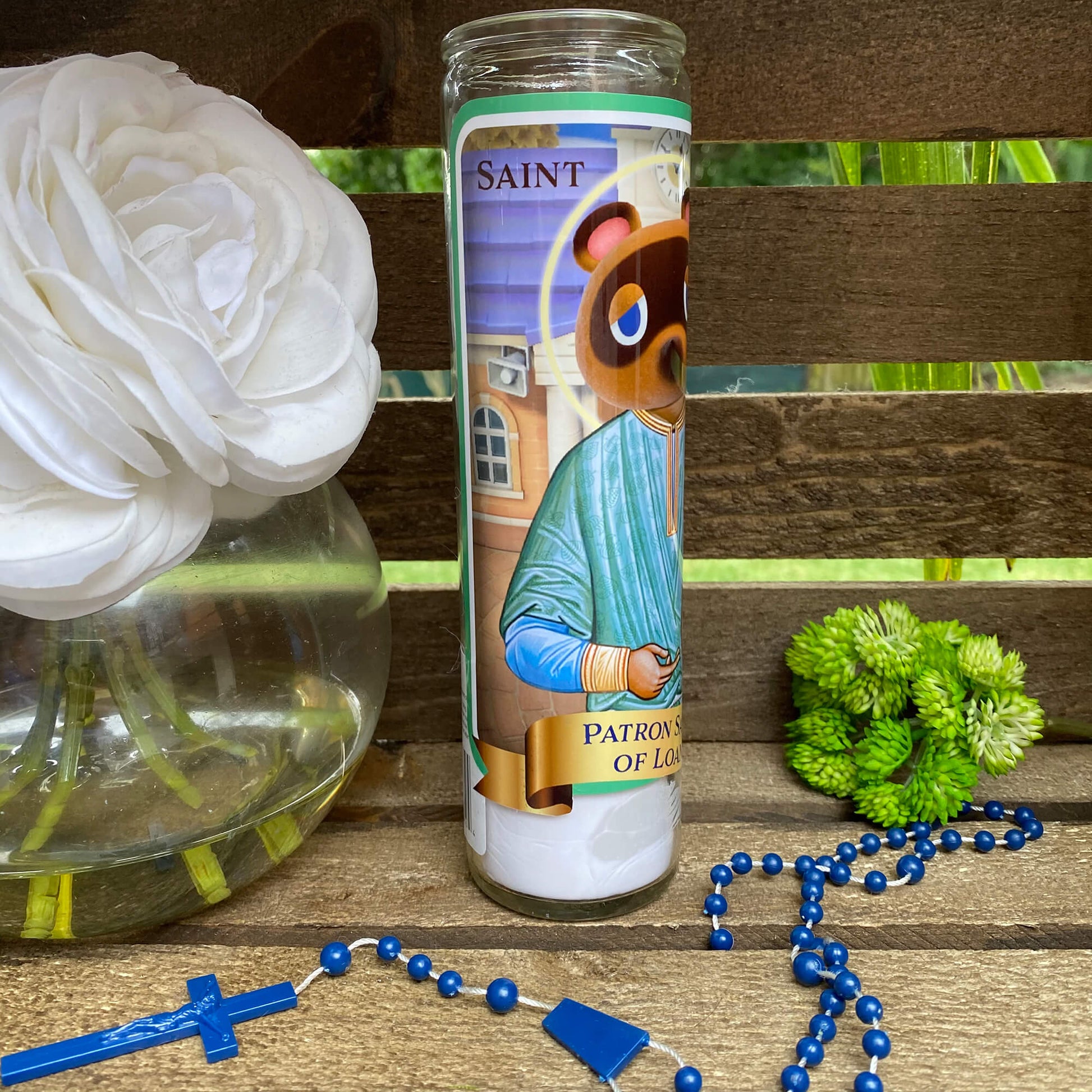 a candle and rosary on a wooden table