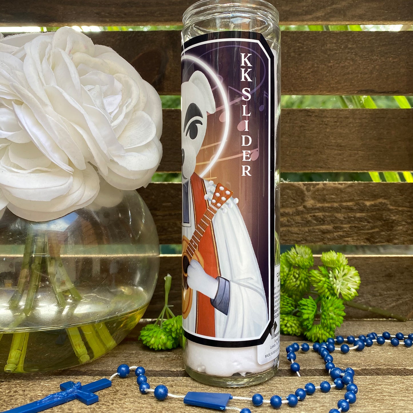 a bottle of liquid next to a flower and beads