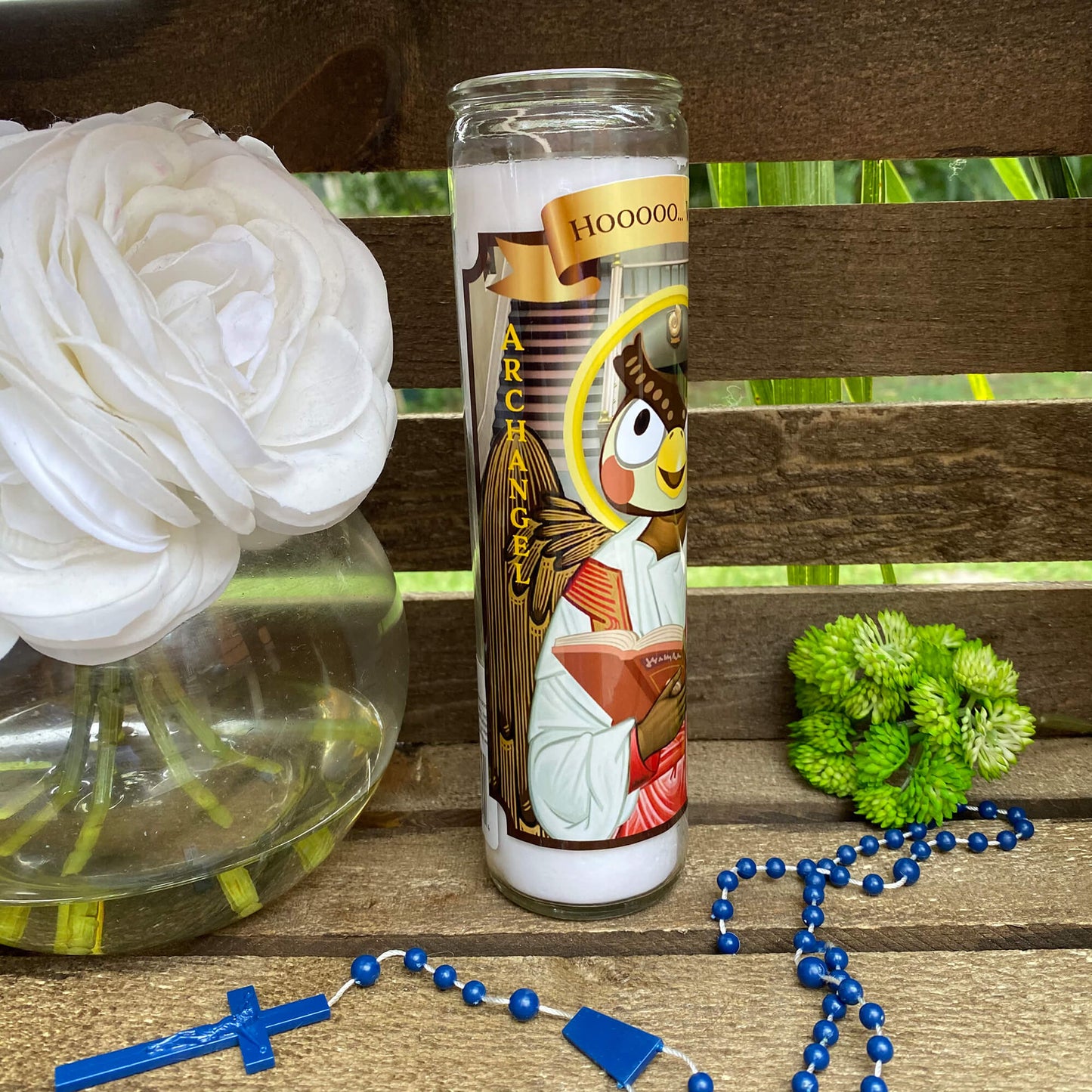 a white rose and a blue rosary on a wooden bench